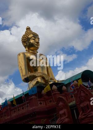 golden buddha statue on top of the temple building from below Stock Photo