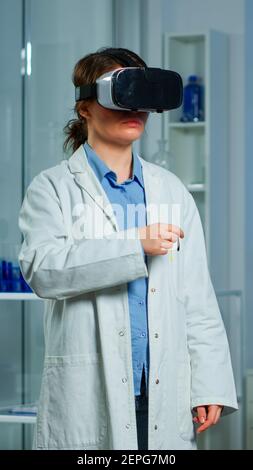 Professional researcher wearing virtual reality glasses using medical inovation in lab analysing brain scan of patient. Team of neurological doctors working with equipment high tech simulator device Stock Photo