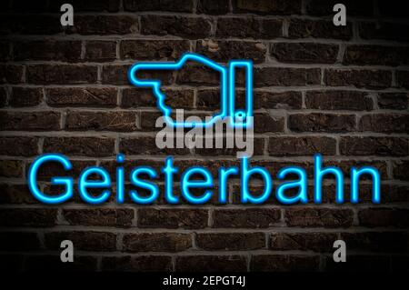 Detail photo of a a neon sign on a wall with the inscription Geisterbahn (Ghost train) Stock Photo