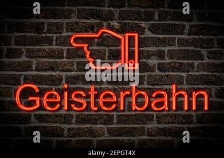 Detail photo of a a neon sign on a wall with the inscription Geisterbahn (Ghost train) Stock Photo