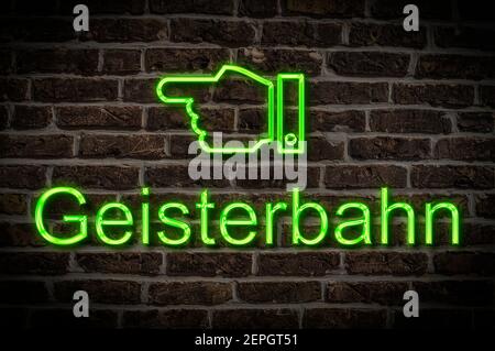 Detail photo of a a neon sign on a wall with the inscription Geisterbahn (Ghost train) Stock Photo