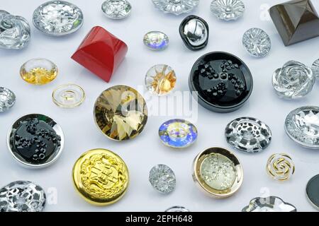 Sew-on plastic buttons of various types and sizes. Large buttons decorated with stones and rhinestones. Decorative buttons for clothes. Stock Photo