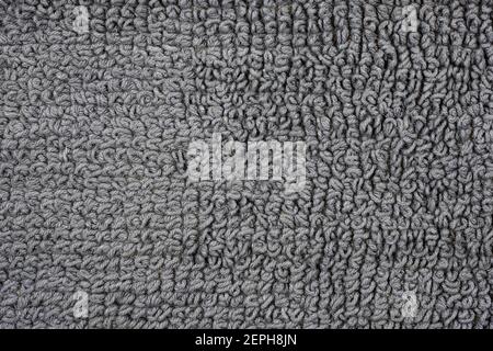 The woven backing of a bath rug in close-up. Gray cotton texture rug top view. Stock Photo