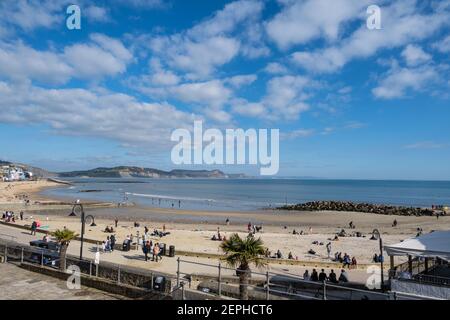 Lyme Regis, Dorset, UK. 27th Feb, 2021. UK Weather: Plenty of people were out and about enjoying unseasonably warm and sunny weather at the seaside resort of Lyme Regis this afternoon. Credit: Celia McMahon/Alamy Live News Stock Photo