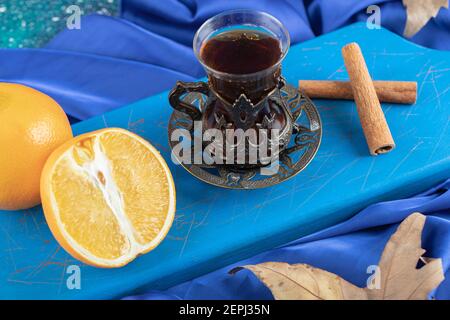 Top view of fresh lemon and fragrant tea with cinnamon on blue wooden board Stock Photo