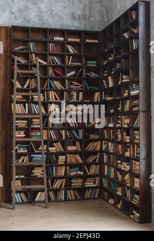 Many books on a wooden shelves in wooden interior, knowledge concept Stock Photo