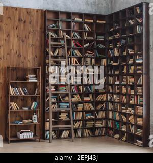 Many books on a wooden shelves in wooden interior, knowledge concept Stock Photo