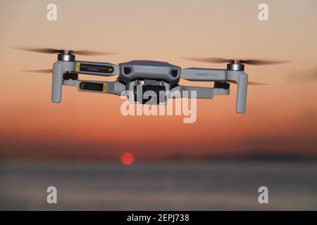 DJI Mavic Mini Drone flying at sunset Stock Photo