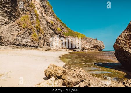 Ocean beach  at low tide near rocks in Bali, Uluwatu Stock Photo