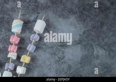 Colorful marshmallows on the wooden sticks to be grilled Stock Photo