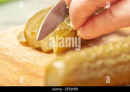 sliced pickle on the kitchen board. preparation of the ingredient for the dish. homemade cooking. slicing process Stock Photo