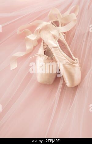 Pretty satin ballet pointe shoes on pink tulle. Stock Photo