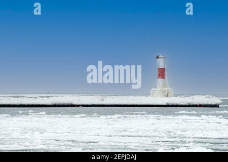 red striped nautical channel marker on Lake Michigan pier in winter Stock Photo