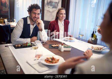 Young business people having a nice talk in a pleasant atmosphere during a lunch at the restaurant. Business, restaurant, lunch Stock Photo