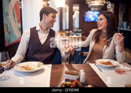 A young couple chatting at the lunch in a cheerful atmosphere at the restaurant. Couple, love, restaurant, together Stock Photo