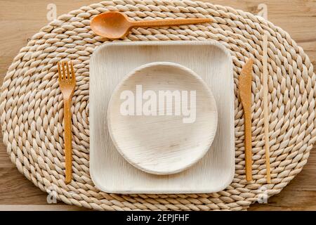 Set of dry biodegradable empty new palm leaf plates and edible fork, knife, spoon and bamboo straw. Perfect zero waste tableware for garden party. Stock Photo