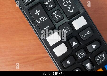 Tv remote control with white bank buttons for on demand services logos on a wooden table Stock Photo
