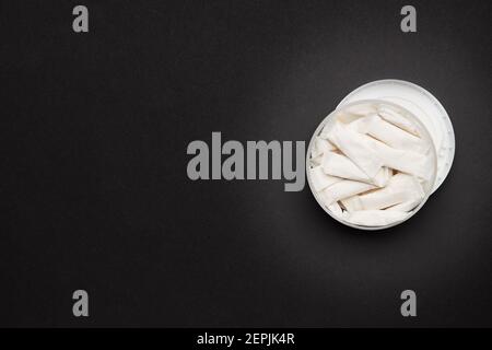 opened container with snus nicotine white bags on a dark background. copy space for design Stock Photo