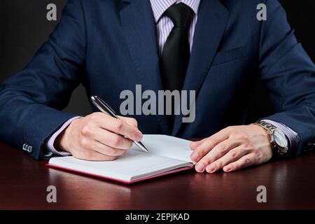 business plan and schedule concept. caucasian businessman write something at his diary book Stock Photo