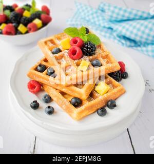 Waffles with powdered sugar and fresh fruit. Stock Photo