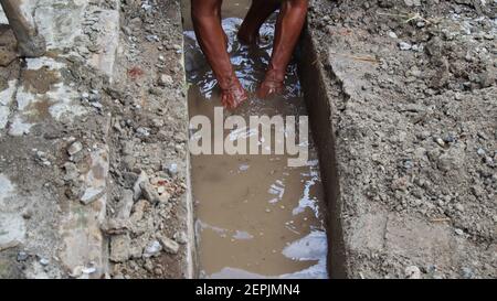 Selective focus image, workers clearing sewers from clogged trash Stock Photo