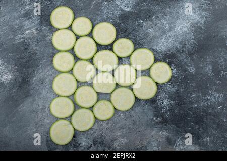 Fresh zucchini slices on a grey background on a triangle shape Stock Photo
