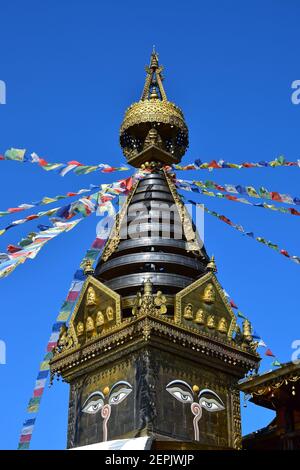 The tower of a buddhist temple with colorful Tibetan prayer flags. Nepal Himalaya Park, Wiesent, Regensburg, Germany. Stock Photo