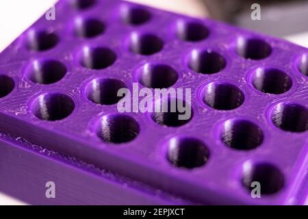 Many holes in purple plastic close up, concept of trypophobia Stock Photo