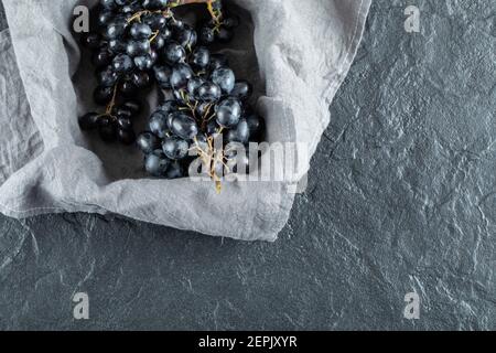Dark fresh grape in basket on a gray tablecloth Stock Photo