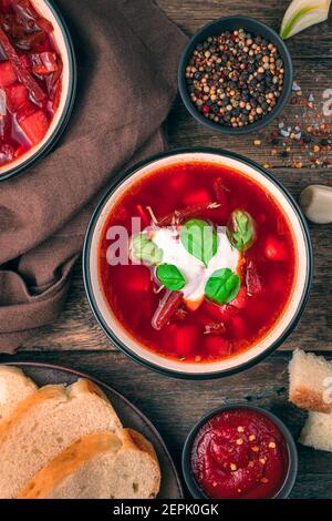 A portion of vegetable soup with tomato and beetroot, sour cream and basil. Fresh, delicious borscht. Stock Photo