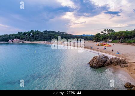 panoramic view of Castelle Beach on the Costa Brava on a summer day with some tourists on the sand, with its turquoise waters and clouds at sunset, Pa Stock Photo