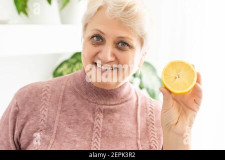 Elderly Person Eating Fruit, elderly woman with lemon Stock Photo
