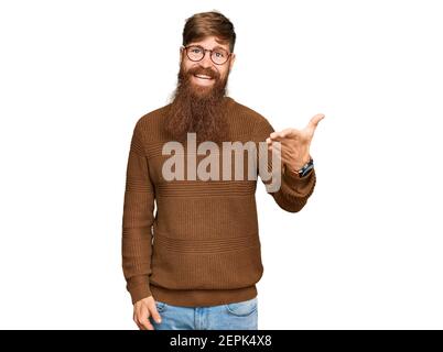 Young irish redhead man wearing casual clothes and glasses smiling friendly offering handshake as greeting and welcoming. successful business. Stock Photo