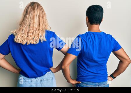Young interracial couple wearing casual clothes standing backwards looking away with arms on body Stock Photo
