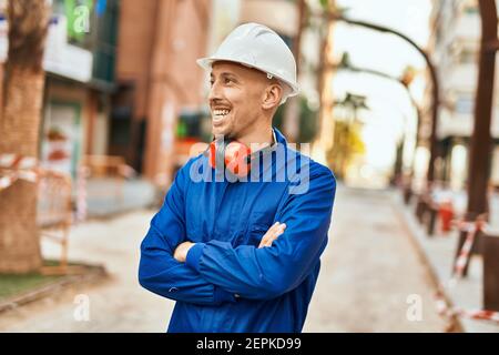 Young caucasian worker smiling happy wearing uniform at the city. Stock Photo