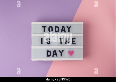 Today is the day - text on display lightbox on purple and pink background. Stock Photo