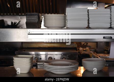 Dishes of various sizes and shapes line a counter in a kitchen in a restaurant Stock Photo