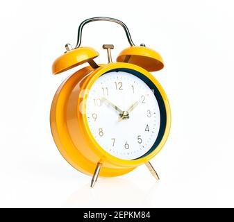 Hand of hispanic man holding yellow alarm clock over isolated white background. Stock Photo