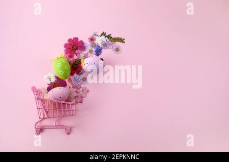 Happy Easter big hunt or sale banner with Colorful Eggs in shopping cart on pink background. Stock Photo
