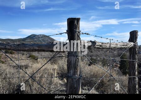 A barbed wire fence defines the boundary of a cattle ranch in New Mexico USA. Stock Photo