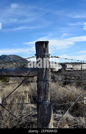 A barbed wire fence defines the boundary of a cattle ranch in New Mexico USA. Stock Photo