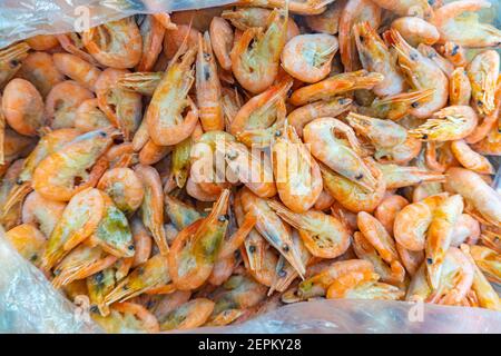 Pink fresh frozen shrimps with ice in a supermarket or fish shop. Fresh frozen prawns, delicacies, sea food concept. Uncooked seafood close up Stock Photo