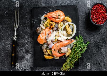 Fresh mix seafood cocktail with shrimps, prawns, mussels, squids and octopus. Black background. Top view Stock Photo