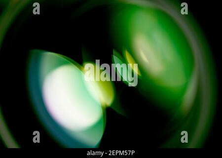 Look into a lens, with green reflections of a round light source Stock Photo