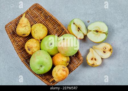Apples and pears in the basket on the grey background Stock Photo