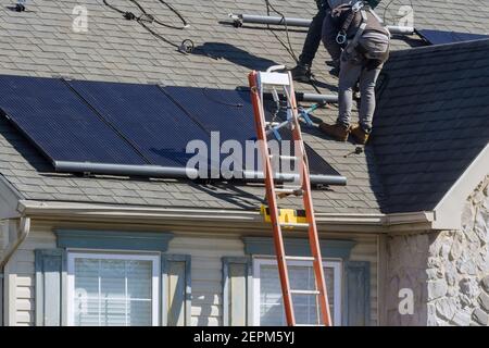 Alternative ecological energy installing solar photovoltaic panel system on roof home Stock Photo