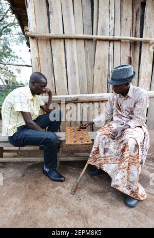 Rwandan men playing Mancala- a traditional African game. Stock Photo