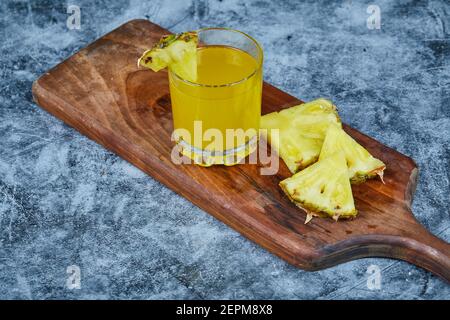Slices of pineapple and pineapple juice on wooden board Stock Photo