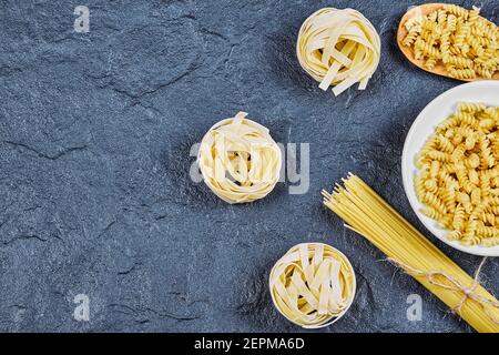 Variety of raw pastas on blue background Stock Photo
