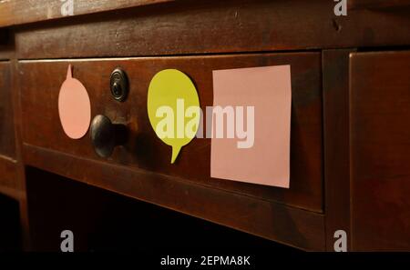 Blank adhesive notes attached to vintage drawer, selective focus on the green note Stock Photo